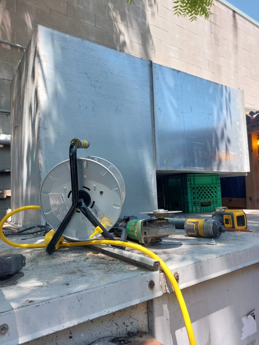 Power tools and cord reel on outdoor HVAC equipment